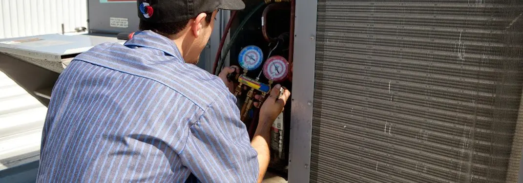 HVAC technician servicing a condenser unit in Bradenton