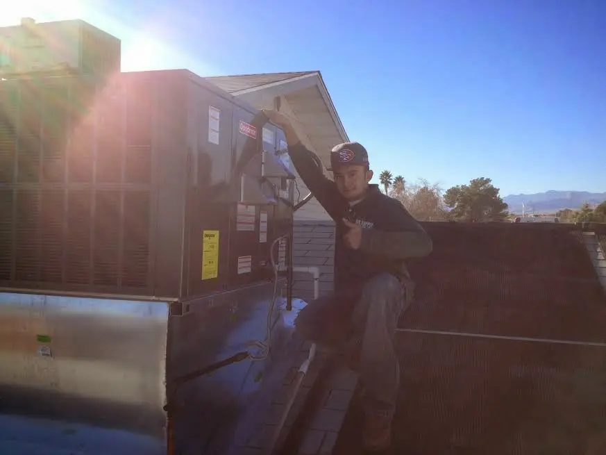 HVAC technician performing AC Tune-Up on a rooftop unit in Bradenton